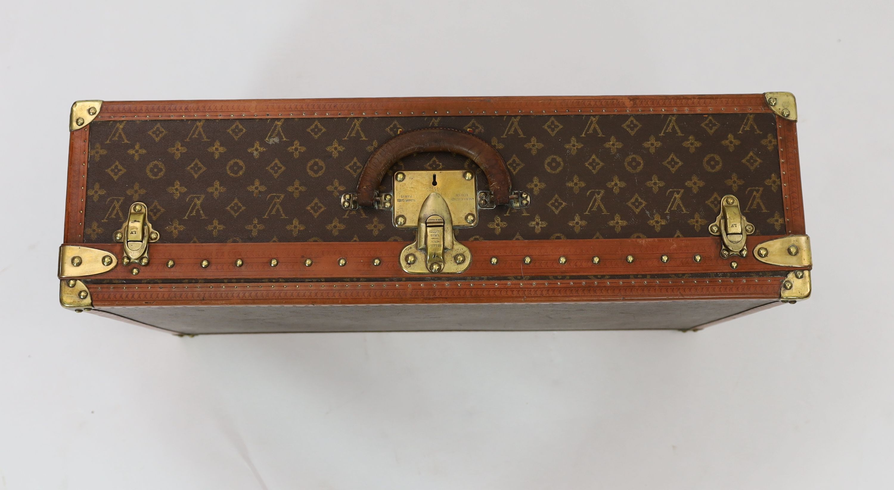 A Louis Vuitton brass mounted leather bound suitcase, 76 x 46cm depth 22cm